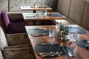 una fila di tavoli in un ristorante con argenteria di Hotel Ladurner a Merano