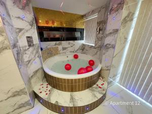 a bathroom with a tub with red balls in it at Mansa Apartments in Bradford