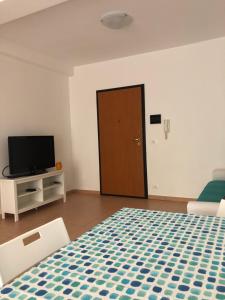Cette chambre comprend un lit, une télévision et une porte. dans l'établissement Alcantara Apartment, à Gaggi