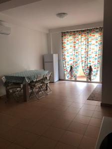 uma sala de jantar com uma mesa e um frigorífico em Alcantara Apartment em Gaggi