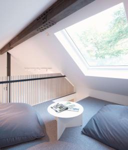 una camera da letto con finestra, letto e tavolo di Eastside - Architect designed retreat with wood-fired sauna a Penicuik