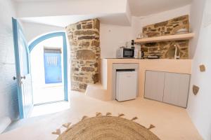 a kitchen with a stone wall and an open door at Private Pool Dame in Mési