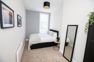 a bedroom with a bed and a mirror at Church Street Apartments in Hartlepool