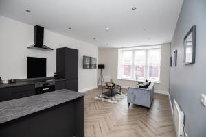 a kitchen and living room with a couch and a table at Church Street Apartments in Hartlepool