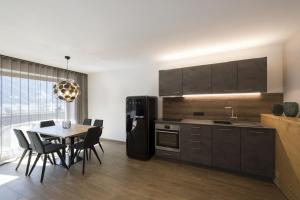 uma cozinha com uma mesa e um frigorífico preto em Residence Sonja - Apartment Betula em Rabla