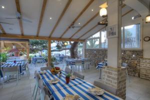 ein Restaurant mit Tischen, Stühlen und einem Kamin in der Unterkunft Gina Bed & Breakfast in Tisno