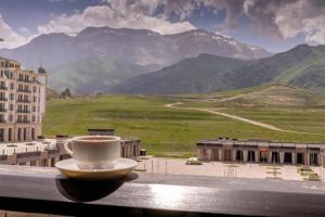 a cup of coffee sitting on the ledge of a building at Shahdag Hotel & Spa in Shahdag