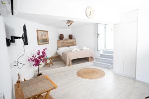 a white bedroom with a bed and a table at Cycladic Art Dame in Mési