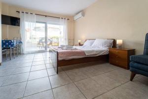 een slaapkamer met een bed en uitzicht op een patio bij Cleri's Studio in Néa Péramos +1 foto