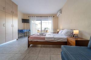 een slaapkamer met een bed en een kamer met een tafel bij Cleri's Studio in Néa Péramos