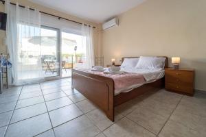 een slaapkamer met een bed en uitzicht op een patio bij Cleri's Studio in Néa Péramos