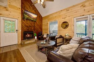 a living room with a couch and a fireplace at King Beds, VIEWS, Fire Pit, Spa, No Fees, New, Private, Games in Sevierville