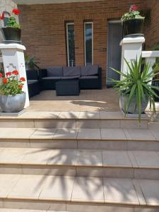 a patio with a couch and potted plants at Chalet Costa Dorada in Tarragona
