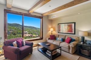 a living room with a couch and chairs and a large window at Edgemont 2504 - Luxury Ski-in Ski-out Condo in Steamboat Springs