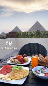 een tafel met twee borden eten en een glas sinaasappelsap bij King hur pyramids inn in Caïro