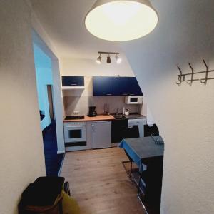 a small kitchen with a table and a large light at Selliner See in Ostseebad Sellin +2 photos
