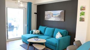a living room with a blue couch and a table at Martini Villas in Nikiti