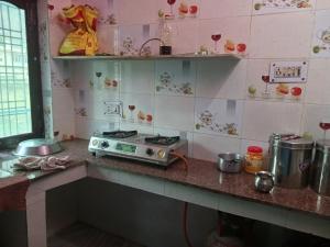 a kitchen with a counter with a stove in it at Somesh Homestay in Uttarkāshi