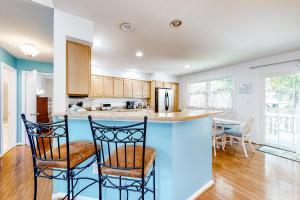 a kitchen with a blue island with two chairs at Octopus Pond Paradise in Ocean City