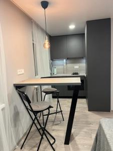 een keuken met een tafel en 2 stoelen in een kamer bij TK apartamenti in Rēzekne