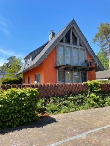 een oranje huis met een zwart dak bij Mueritzblick47 in Marienfelde