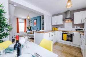 a kitchen and living room with a table and yellow chairs at Stylish 2-bed home in Chester City-Centre by 53 Degrees Property, ideal for Couples & Small groups, Great Location - Sleeps 5 in Chester