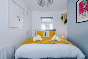 a white bedroom with a large bed with yellow pillows at Stylish 2-bed home in Chester City-Centre by 53 Degrees Property, ideal for Couples & Small groups, Great Location - Sleeps 5 in Chester