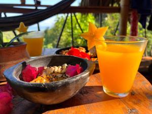 uma tigela de comida e um copo de sumo de laranja em Finca La Selvita em Buritaca