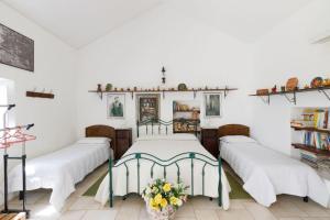 マルティナ・フランカにあるMasseria Pozzo Tre Pileのベッドルーム(白いシーツが備わるベッド3台付)