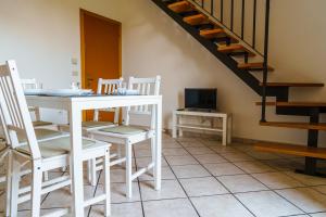 une chambre avec une table, des chaises et un escalier dans l'établissement Dullos' House, à Lido Adriano