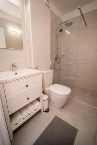 ein weißes Badezimmer mit Toilette und Dusche in der Unterkunft Studio SARA in Saturn
