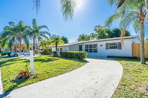 a house with palm trees in front of a driveway at Peaceful 3 Bedroom House with Relaxing Backyard 15 minutes to the Ocean in Hollywood