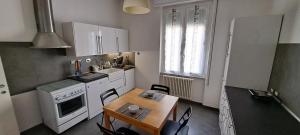 uma cozinha com uma mesa, um fogão e um lavatório em Waterfront Apartment em La Spezia