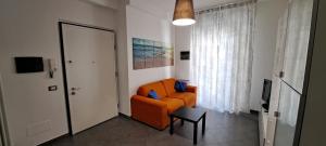 uma sala de estar com uma cadeira laranja e uma mesa em Waterfront Apartment em La Spezia