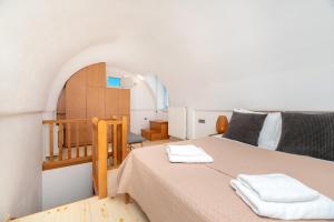 ein Schlafzimmer mit einem Bett mit zwei Handtüchern darauf in der Unterkunft Johnny’s House in Imerovigli