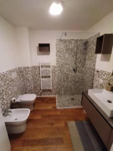 a bathroom with two toilets and a shower and a sink at In viaggio con Pippo - Ampio appartamento con AC nei pressi di Piazza Bovio e del Rivellino in Piombino