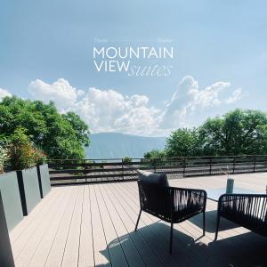 twee banken op een terras met uitzicht op de bergen bij Mountain View Suites in Tisens