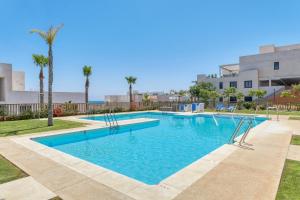 - une piscine d'eau bleue avec des palmiers dans l'établissement Casa Banderas, Sea and Mountain View at Luxury complex, à La Cala de Mijas