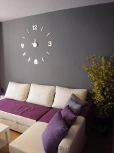 sala de estar con sofá y reloj en la pared en Casa Chema I - Apartamento/Parking/Piscina/Playa, en Cala del Moral