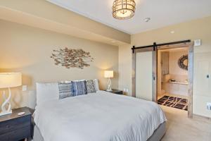 a bedroom with a large white bed and a bathroom at Edgemont 2605 - Luxury Ski-in Ski-out Condo in Steamboat Springs