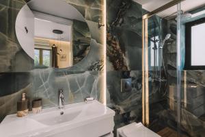 a bathroom with a sink and a mirror at Bonos apartments in Stoupa +21 photos