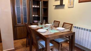 a wooden table with chairs and plates and wine glasses at Casa gorgona in León