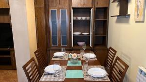 a dining room with a table and chairs with plates and wine glasses at Casa gorgona in León +4 photos