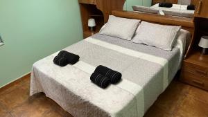 Un dormitorio con una cama con dos zapatillas negras. en Casa gorgona, en León