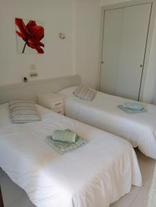 two white beds sitting next to each other in a room at luxmar beach in Benidorm