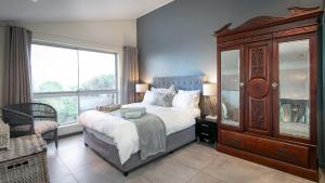 a bedroom with a large bed and a large window at Noordhoek Bliss Beach House in Cape Town