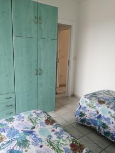 パエストゥムにあるstefaniaのベッドルーム1室(ベッド2台、緑のキャビネット付)