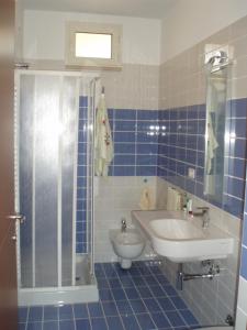 bagno piastrellato blu con doccia e lavandino di Villa Il Melograno a Vasto