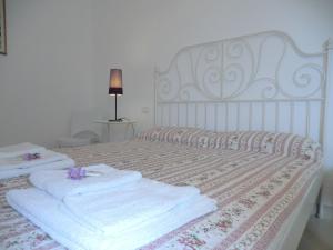 un letto bianco con sopra asciugamani di Villa Il Melograno a Vasto