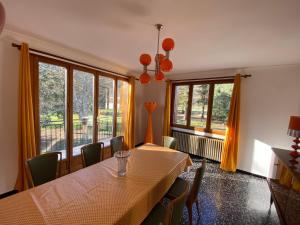 ein Esszimmer mit einem Tisch, Stühlen und Fenstern in der Unterkunft NOUVEAU Villa Olga in Jaujac